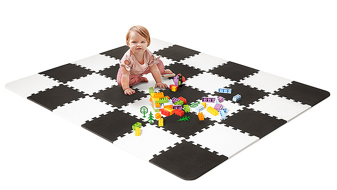 Sur un fond blanc se trouvent des puzzles noirs et blanc en mousse de la marque Kinderkraft. Une fille qui joue aux blocs est assise dessus.