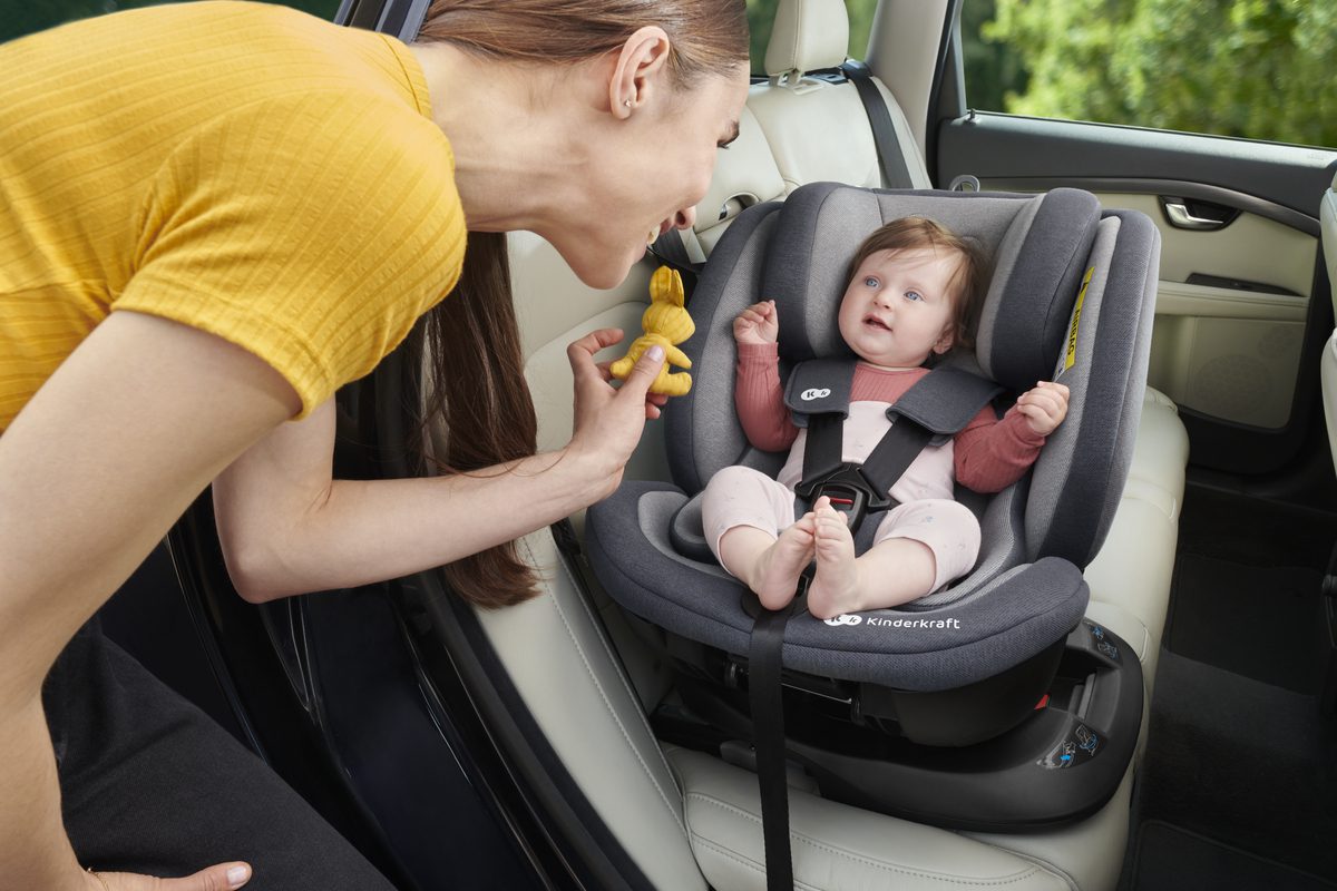 Enfant dans un siège auto pivotant fixé dans la voiture à l'aide du système ISOFIX